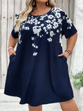 Abito T-shirt con tasche asimmetriche e stampa floreale in taglie comode, adatto per vacanze, outfit estivi da donna, abiti da spiaggia, abiti da laurea o per il tè.